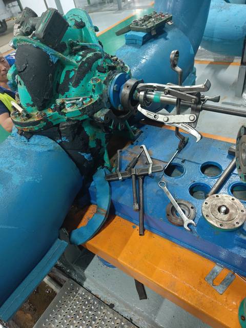 工作人员使用拉拔工具处理中央空调冷冻泵轴端