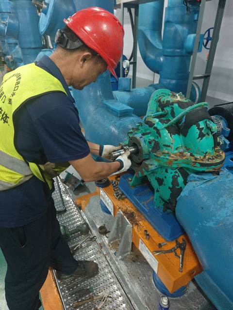 工作人员在中央空调冷冻水泵轴端位置进行维护作业