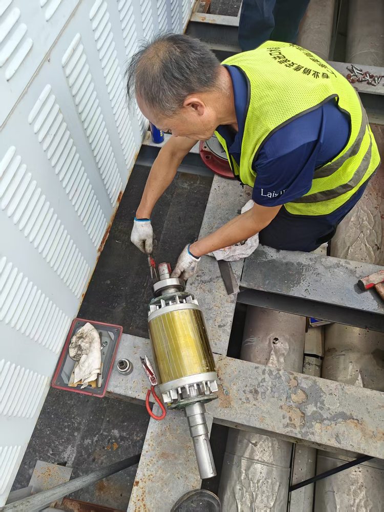 莱胤员工在工作台前处理电机转子与轴组件