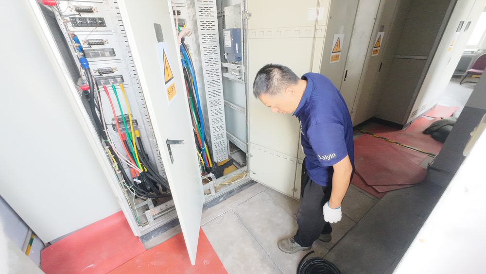 作业人员在开启的控制柜旁检查柜内接线区域